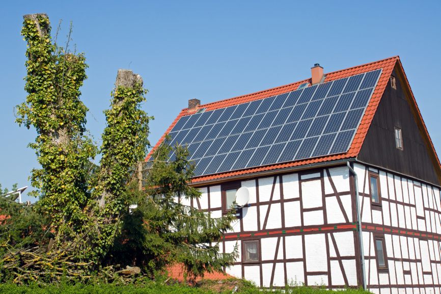 Old frame off grid solar home with rooftop panels lowering the average monthly electric bill with solar panels.