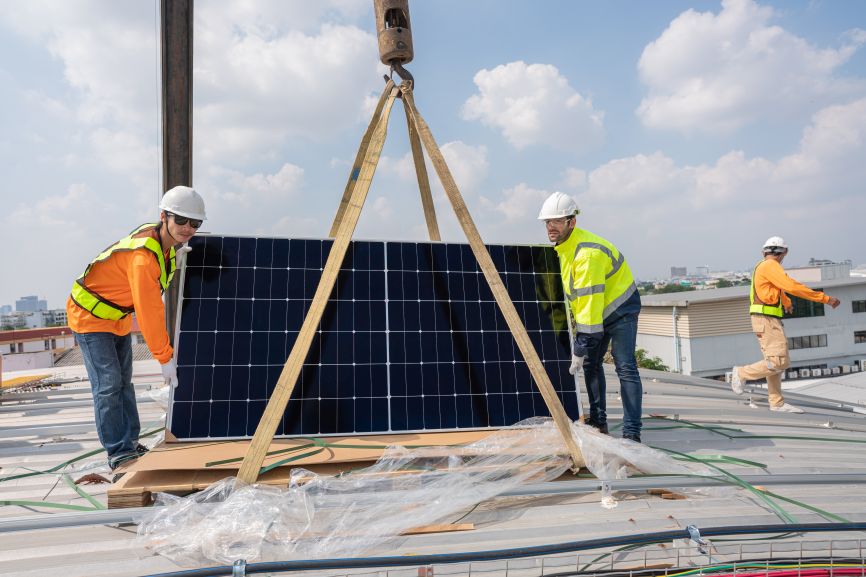Technicians using a crane for solar panel removal in dallas