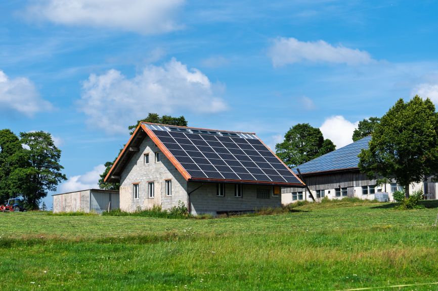 Tiny off grid home with small solar panel setup in the backyard