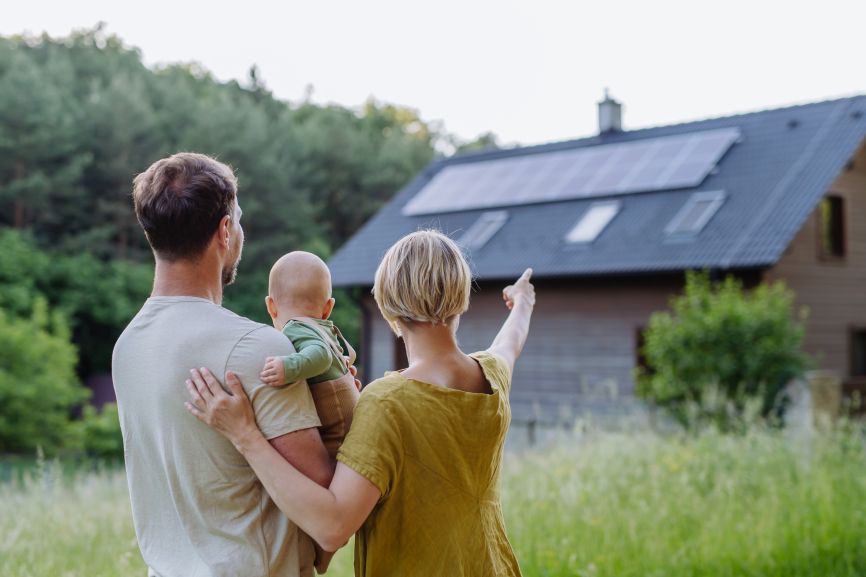 Family looking at their solar-powered home, illustrating the question Can Solar Panels Power a Whole House? installed by First Solar Installers
