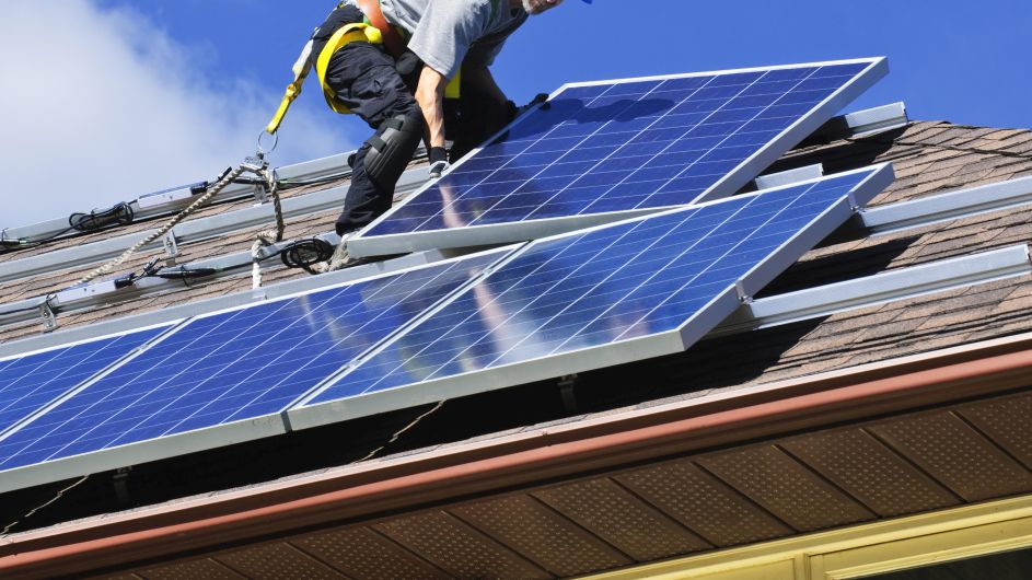 Technician removing and reinstalling solar panels on a residential roof by First Solar Installers, representing companies that remove and reinstall solar panels.
