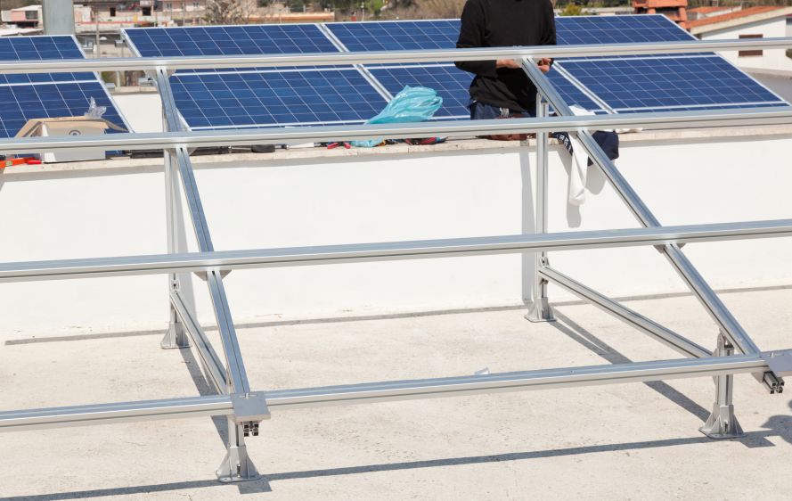Contractor assembling aluminum solar panel rails on a flat residential roof by First Solar Installers demonstrating how to install solar panel rails on roof