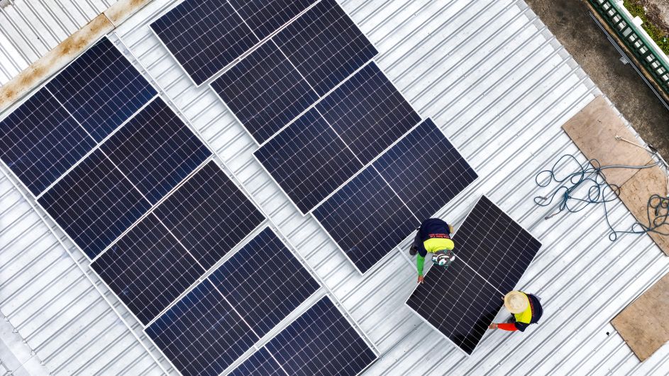 Workers installing solar panels on a rooftop by First Solar Installers - Series and Parallel Solar Panels